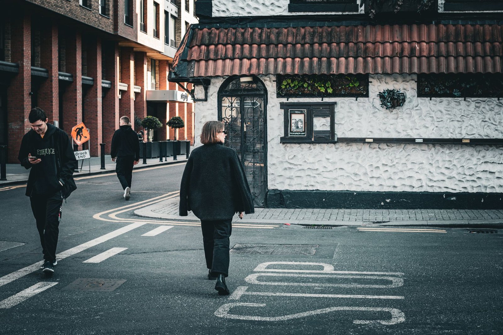 Candid street scene with people walking past textured wall in Dublin, Ireland.