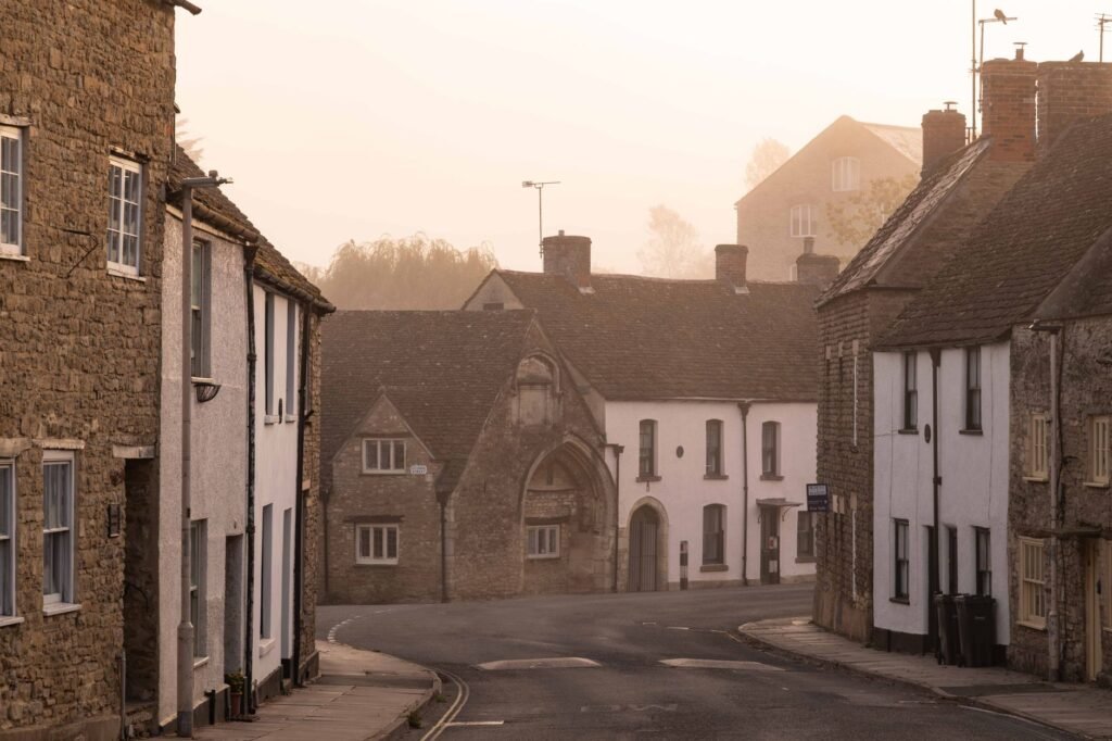 Peaceful village street with stone cottages at sunrise in a misty atmosphere.