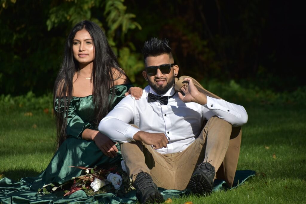 Stylish couple posing outdoors in Surrey, capturing romance and fashion amid lush greenery.