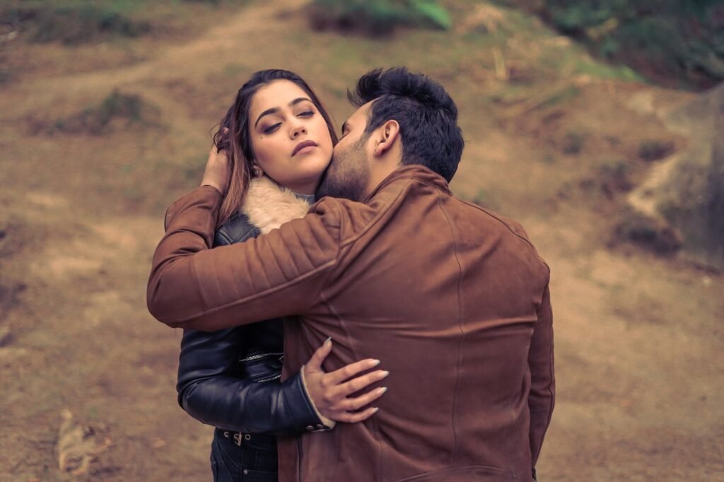 Couple sharing an intimate moment outdoors, evoking romance and affection.