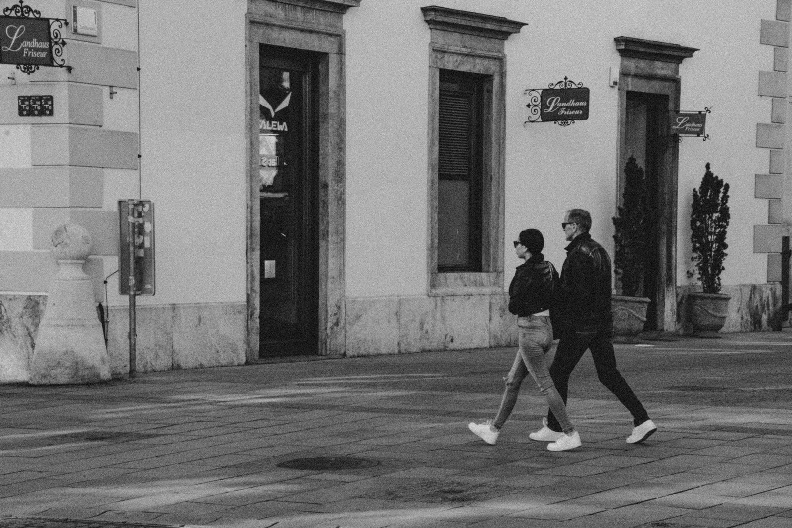 A couple walking in Graz, Austria, captured in black and white, embracing the classic street style.