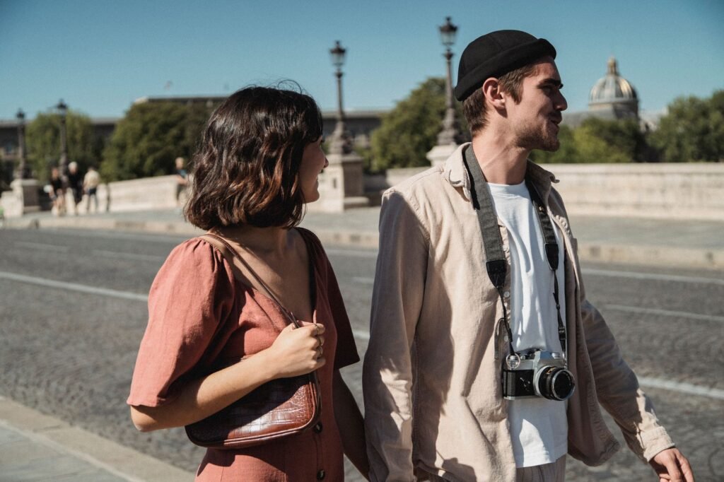 A couple enjoying a day out, walking on a sunny city street with vintage camera.