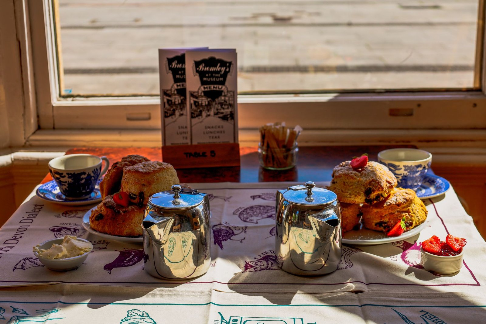 Inviting afternoon tea setup with scones and tea in England cafe.