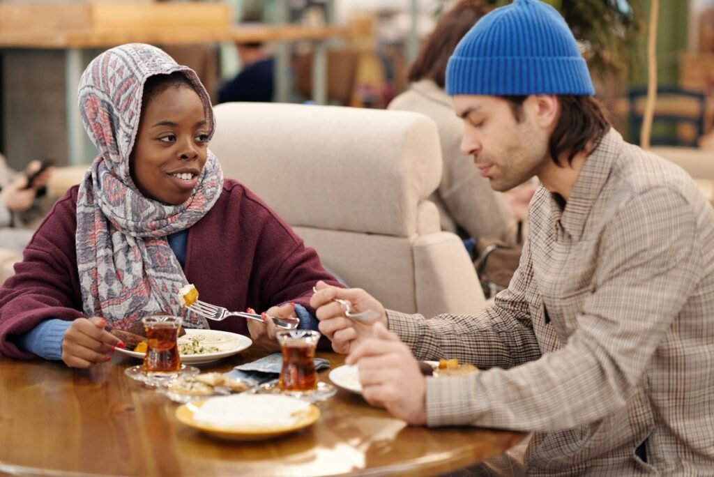 A multicultural couple having a pleasant meal together in a cozy cafe setting.