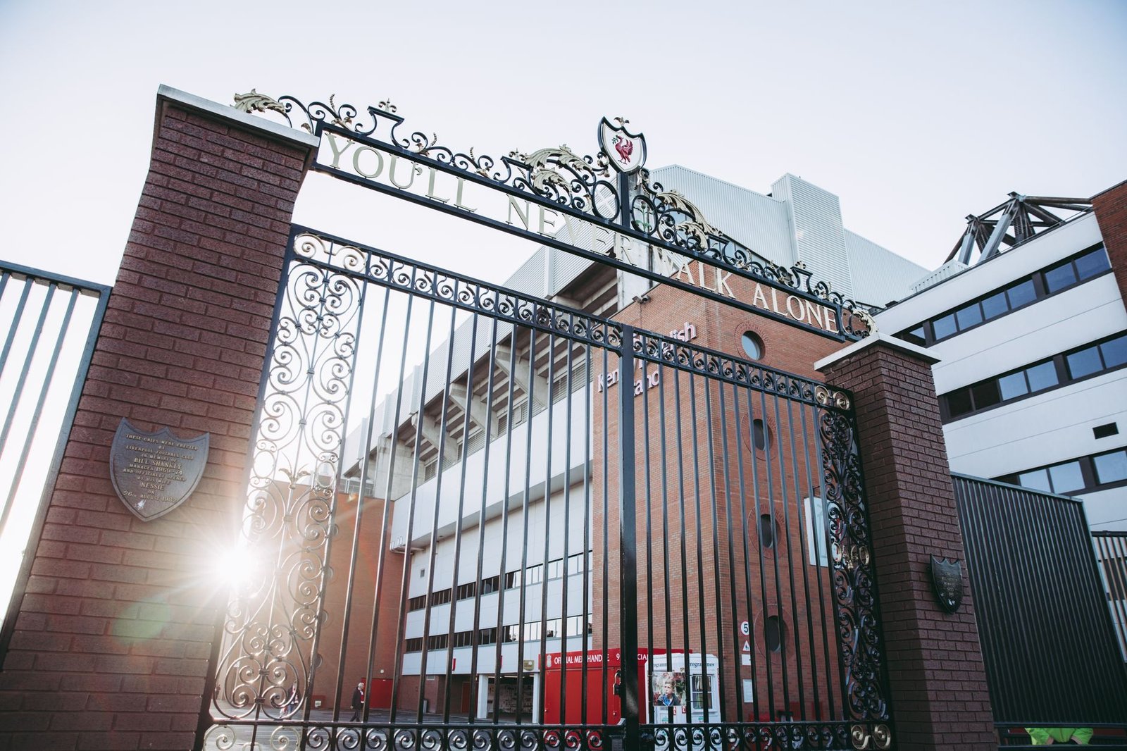 A photo capturing the iconic gates of Anfield Stadium, Liverpool, with sunrays illuminating the architecture.