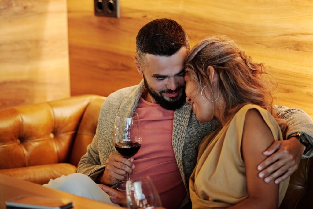 Loving couple embracing with wine glasses. Perfect cozy moment indoors.