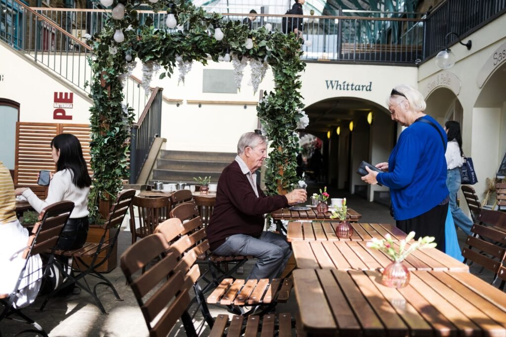 Lively indoor café in London featuring patrons interacting in a cozy setting with rustic tables.