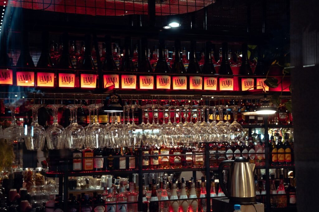Stylish bar interior showcasing an array of hanging glassware and illuminated shelves.