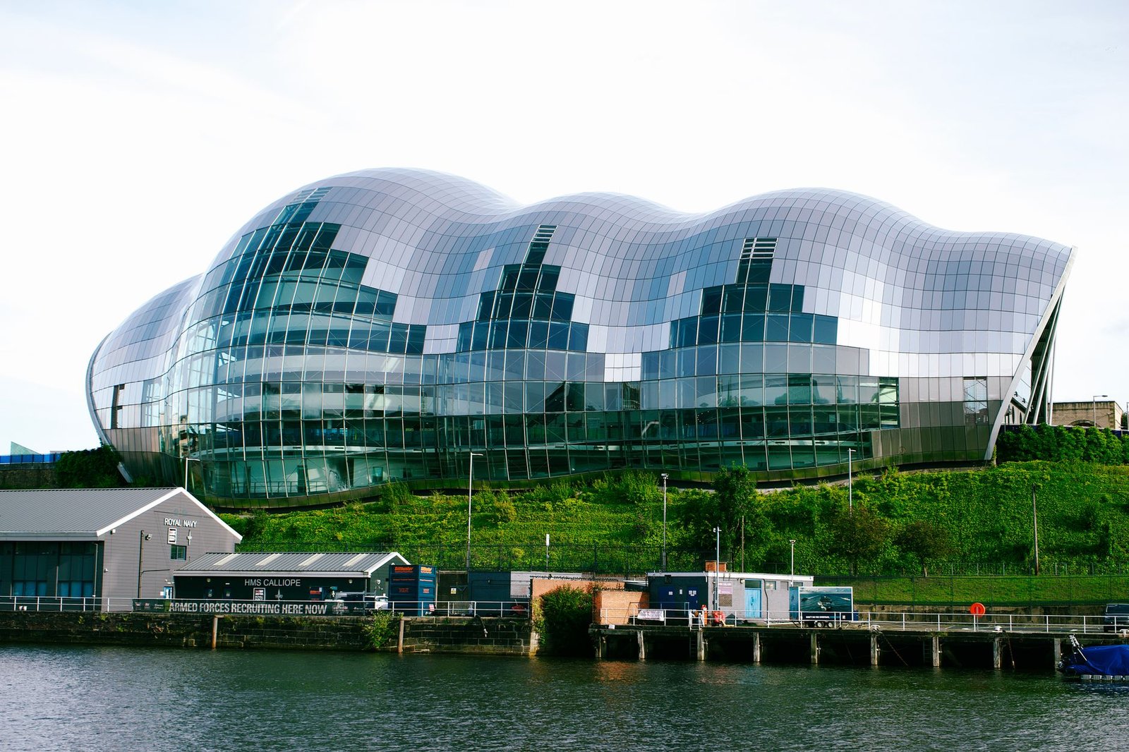 Sage Gateshead's modern glass structure reflecting on the River Tyne, England.