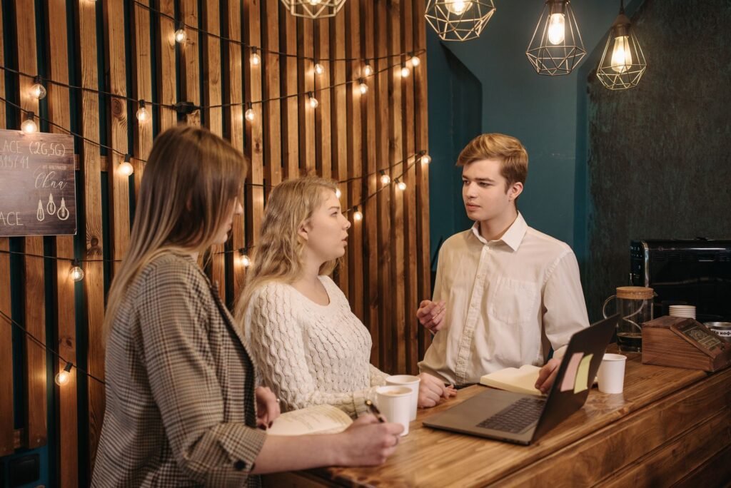 Group of young adults discussing and collaborating at a cozy coffee shop.