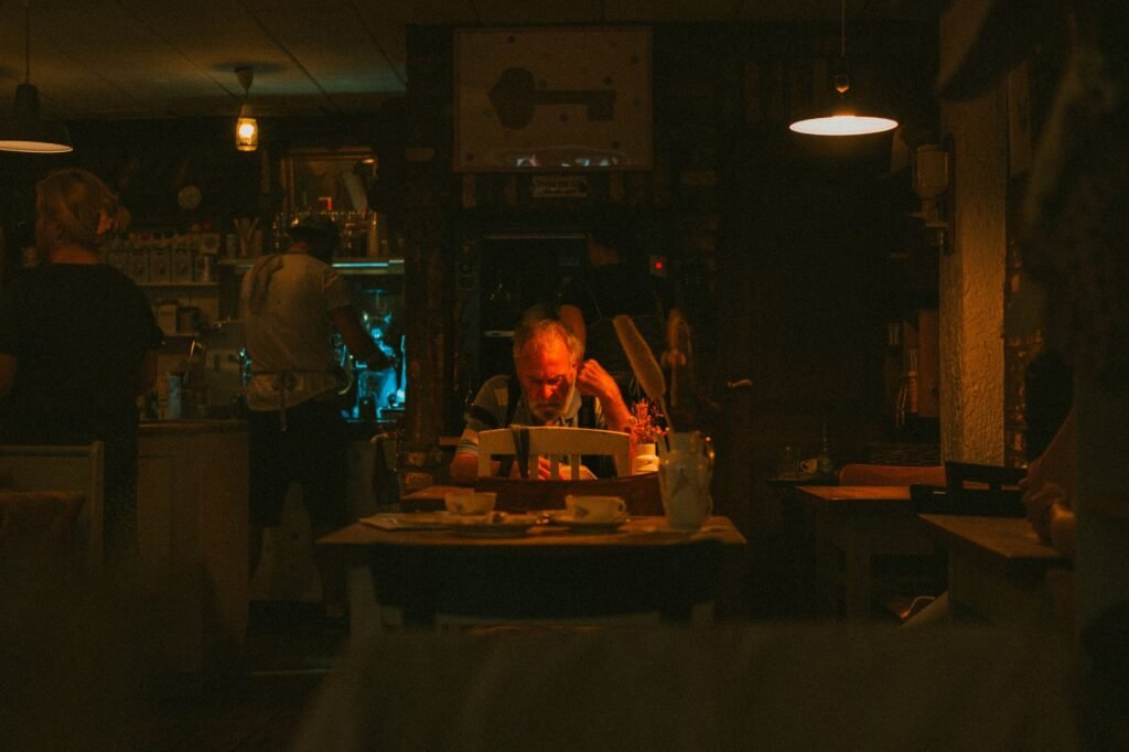Warmly lit interior of a German café with people dining and enjoying a relaxed atmosphere.