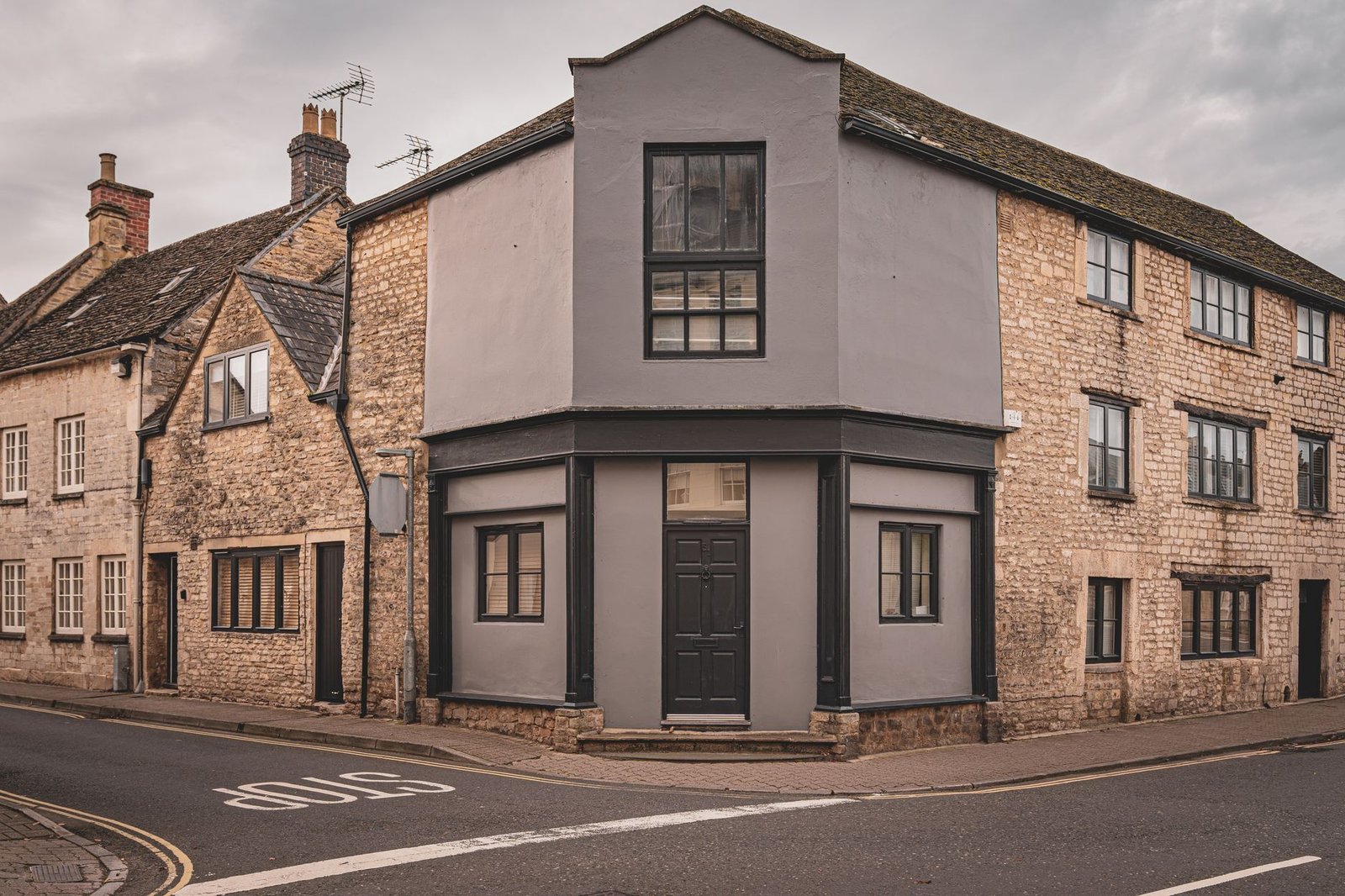 Rustic English stone buildings on a tranquil street corner, showcasing classic architecture.