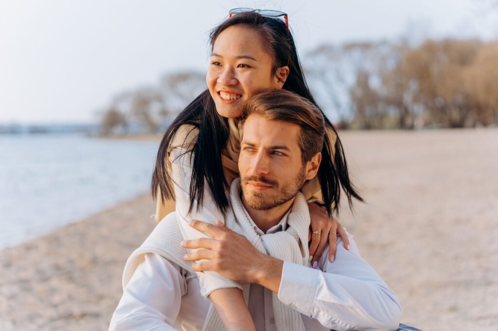 Happy couple embracing on a serene beach, radiating love and joy.
