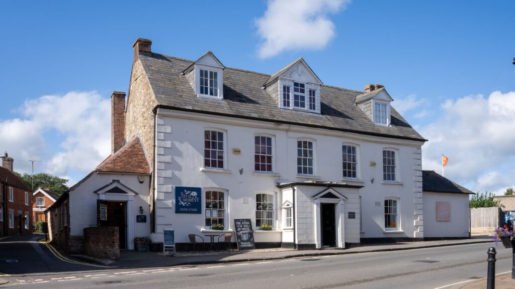 Charming historical café building in Sturminster Newton, England, under a bright blue sky.