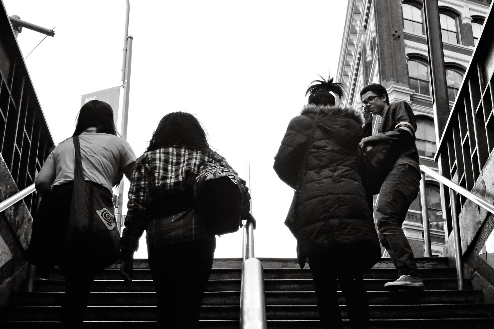 Black and white photo of people walking up stairs in New York City.