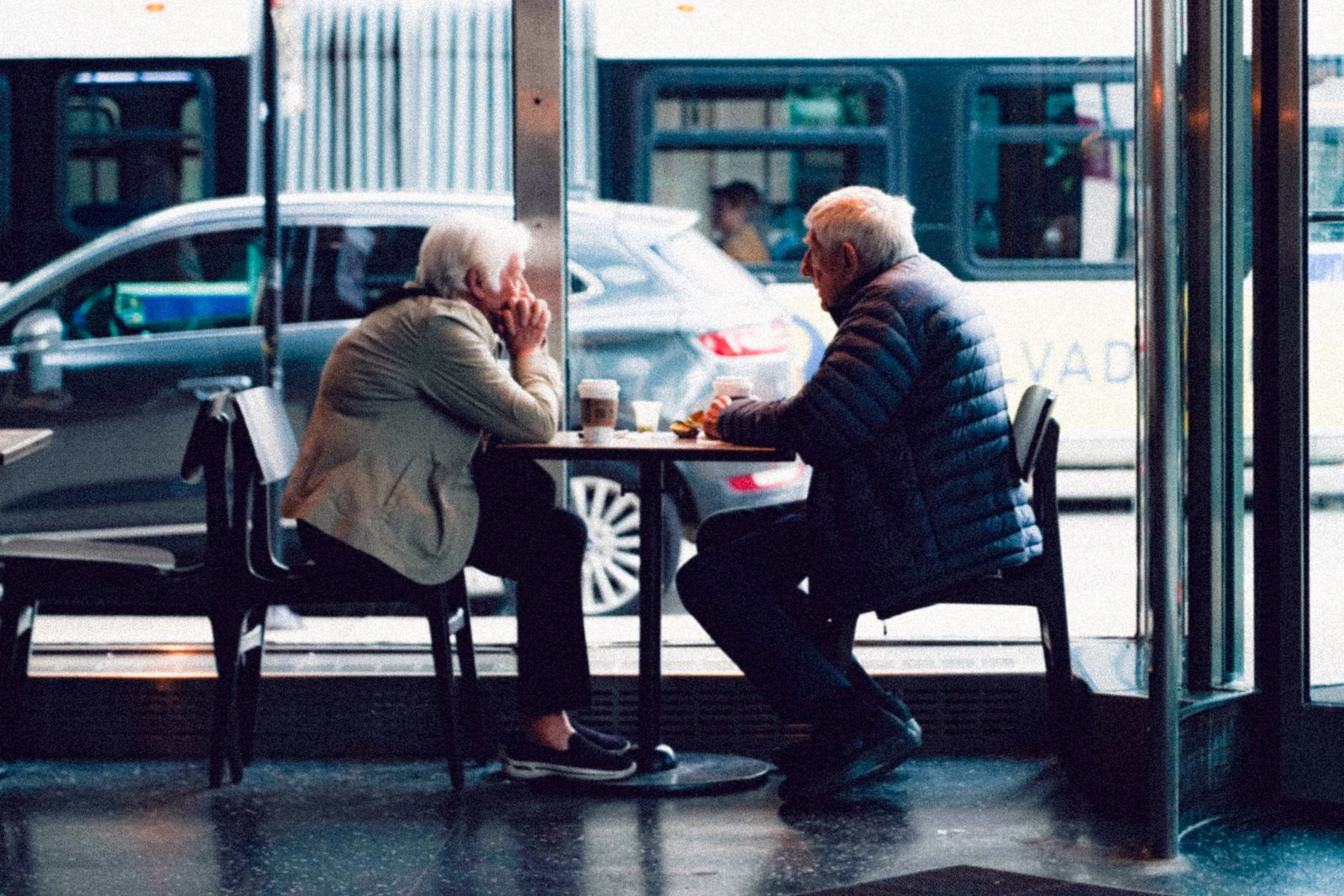 An elderly couple sharing a moment over coffee in a cozy café setting.