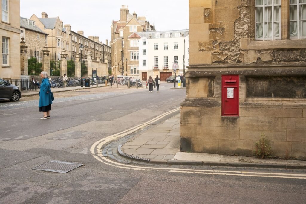 City street with historic buildings and a red mailbox, capturing daily life and architecture.