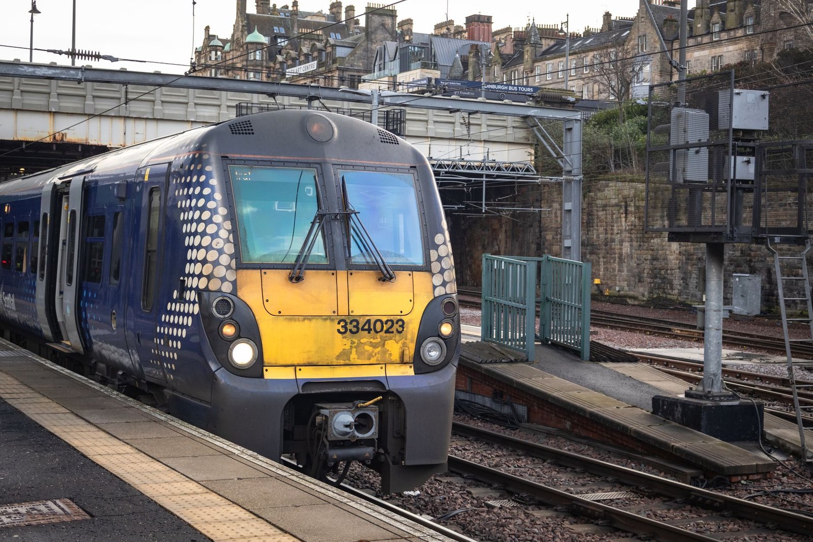 A ScotRail train at a platform in Edinburgh, Scotland, showcasing urban transit.