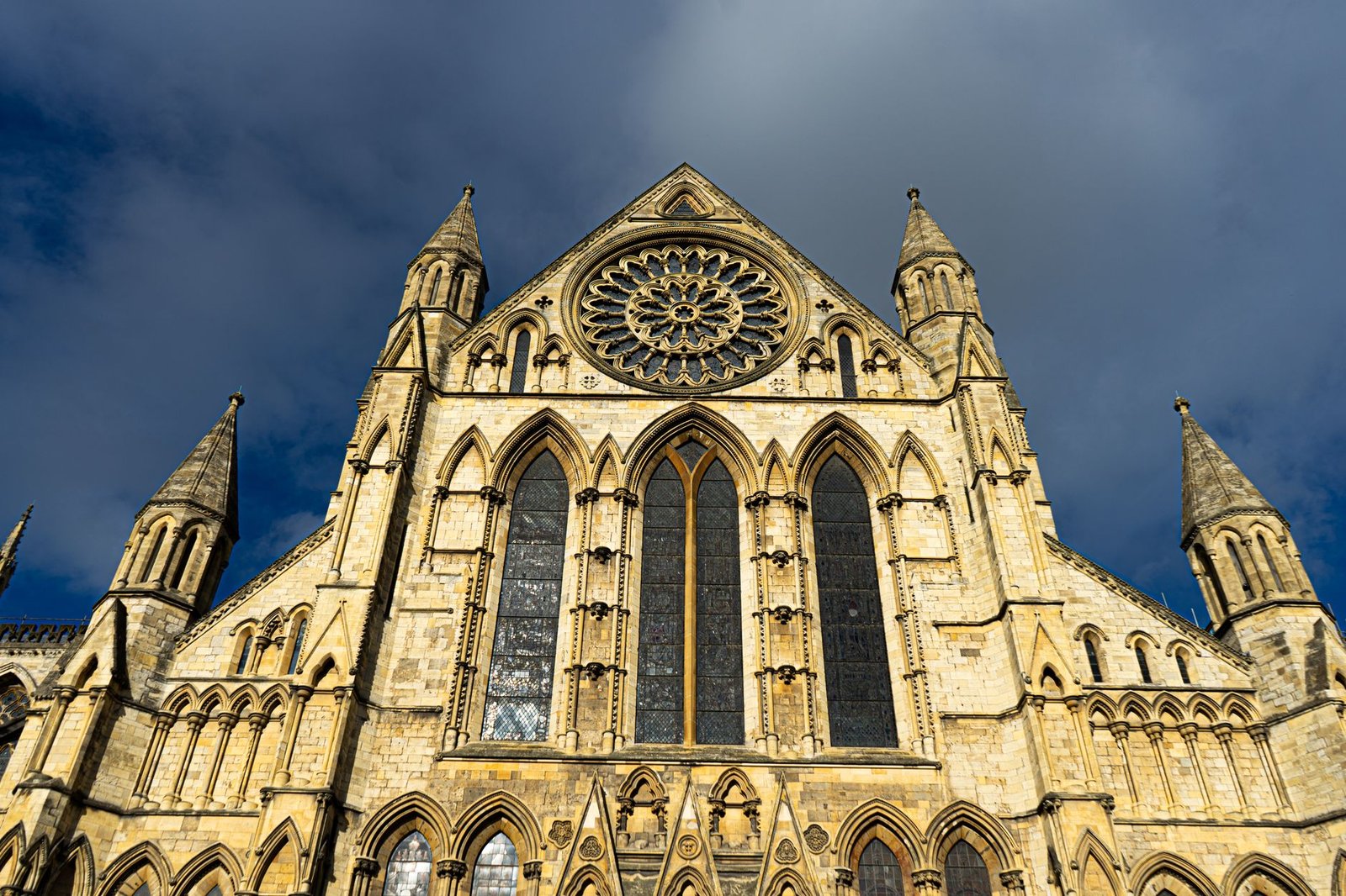 Low-angle view of York Minster's gothic architecture under a dramatic sky.