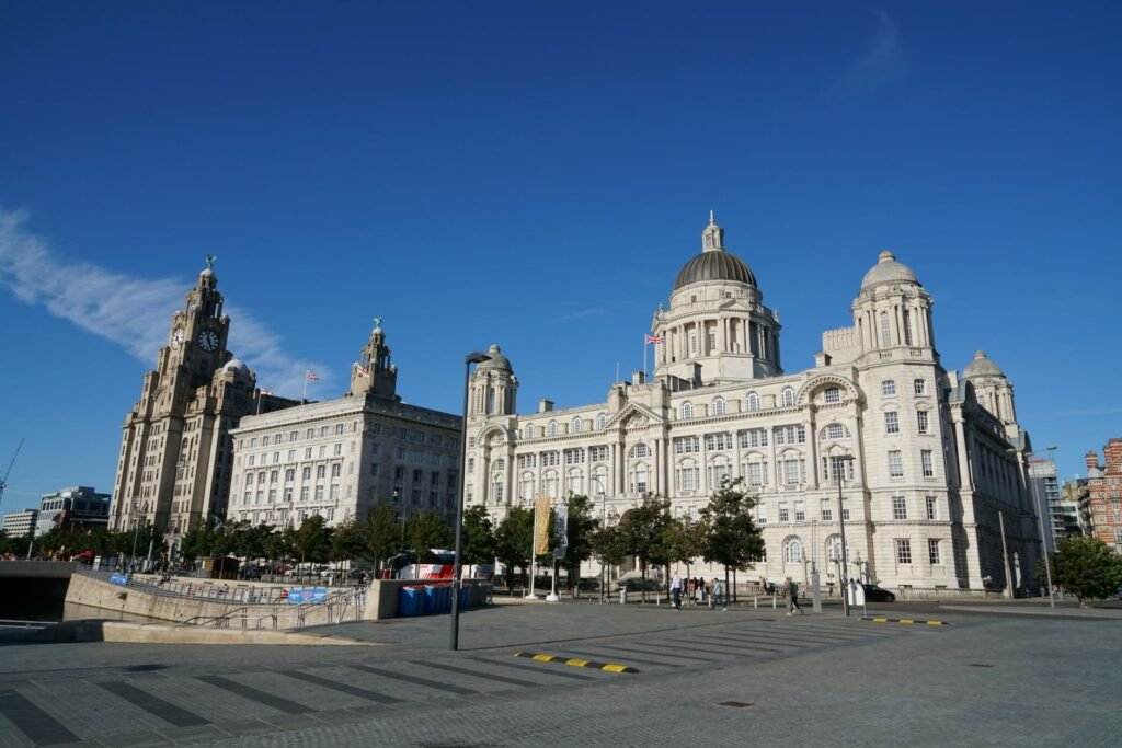 The historic Three Graces overlooking the River Mersey in Liverpool on a sunny day.