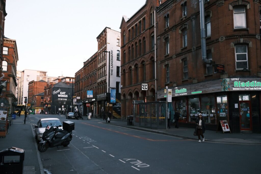 A bustling urban street lined with historic red brick buildings and shops.