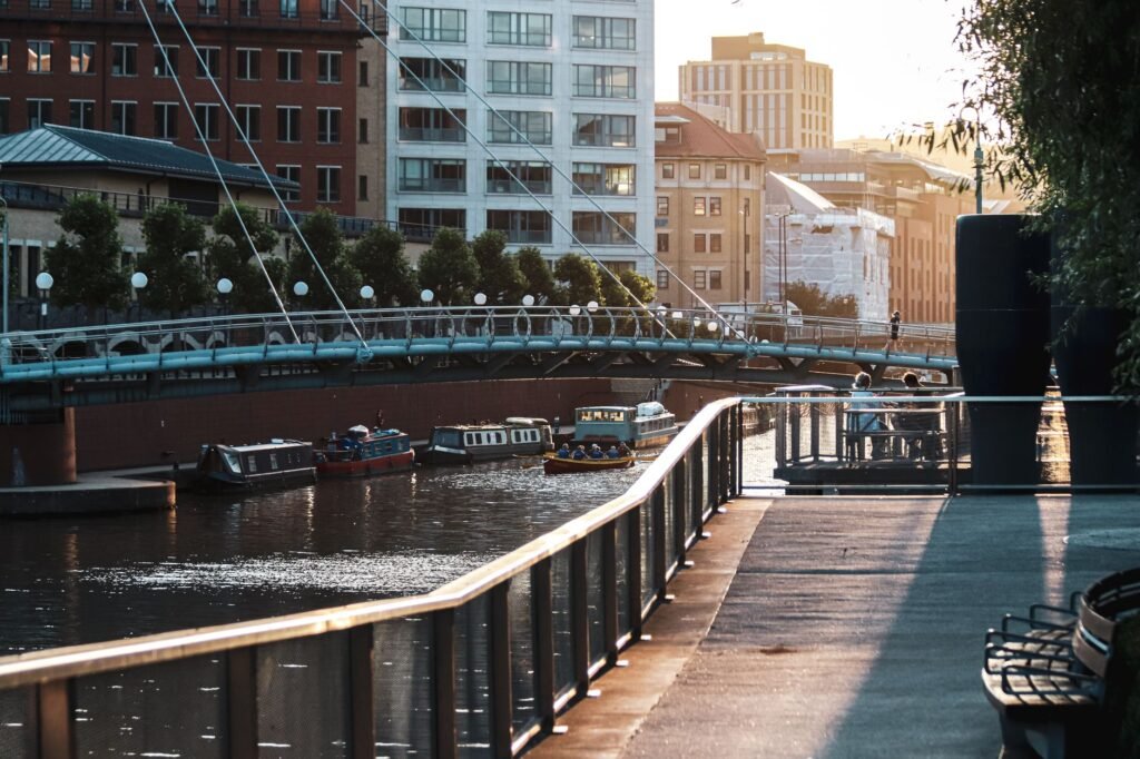 Beautiful sunset view of a canal with boats and a bridge in a vibrant urban setting.