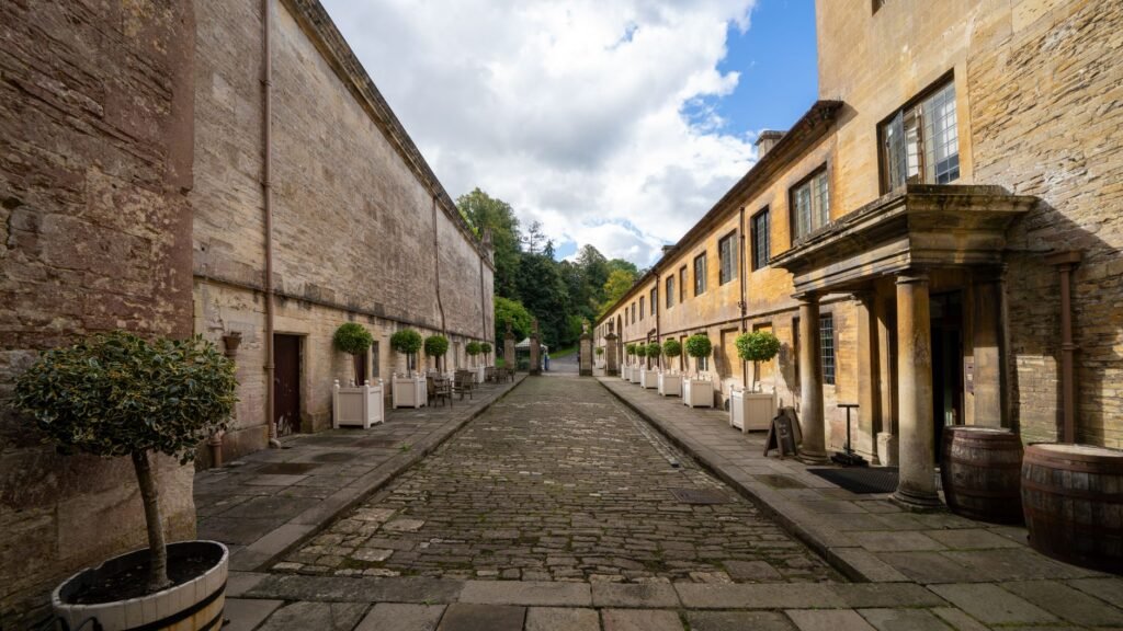 Charming cobblestone alley in Dyrham, England with historic architecture.