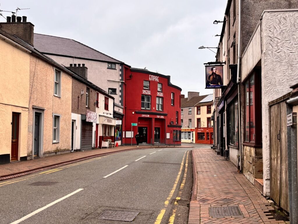 Colorful street with iconic red cinema building, peaceful and inviting atmosphere.