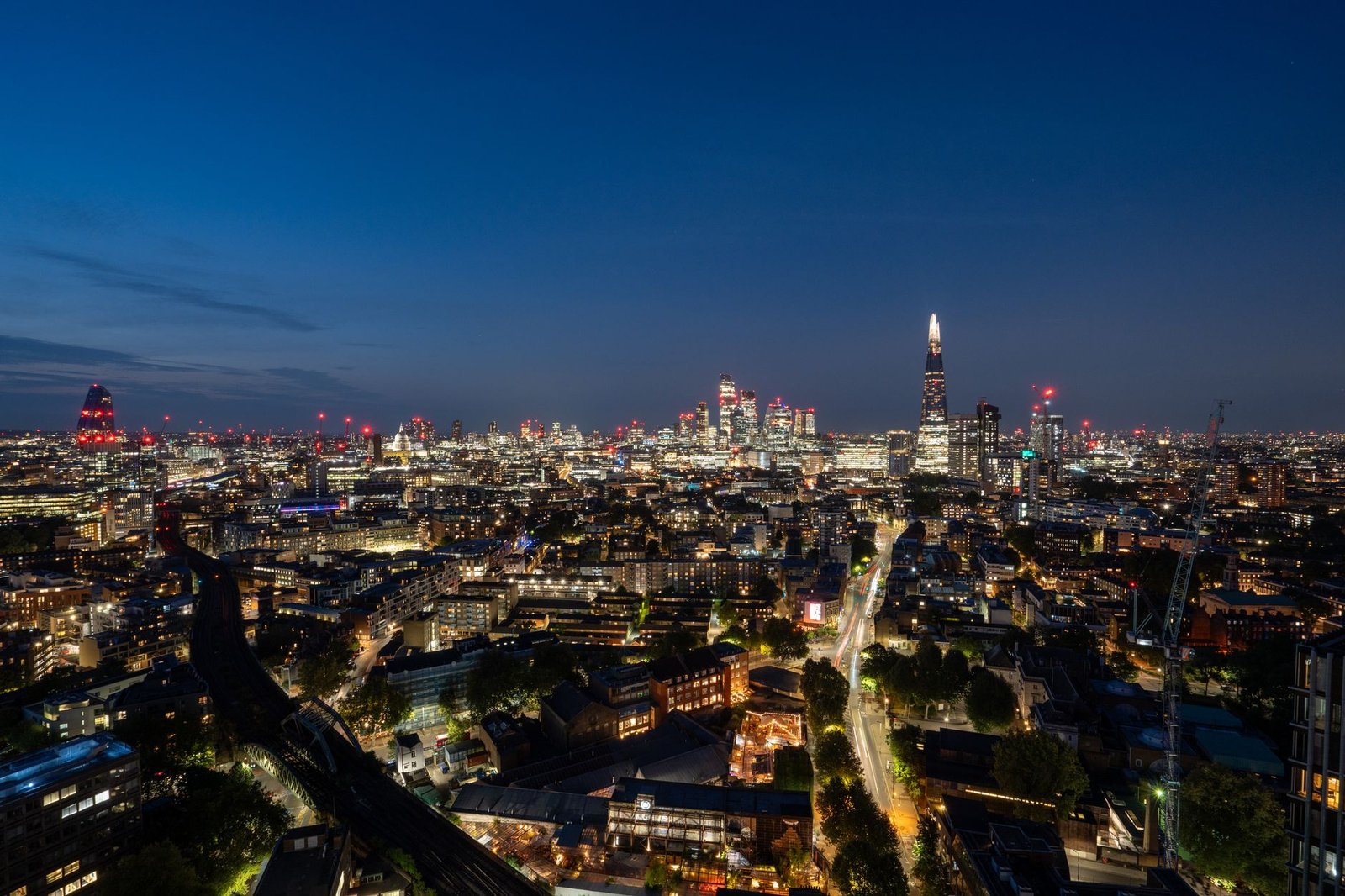 A breathtaking aerial view of London's skyline at night featuring the iconic Shard building.