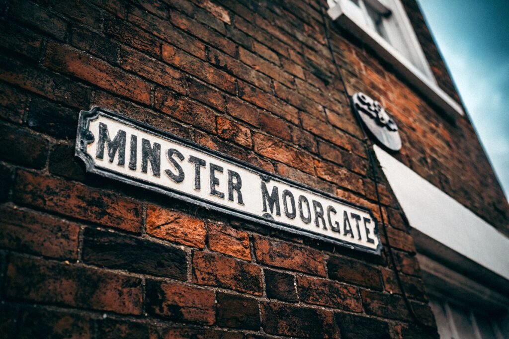 A classic brick wall featuring the street sign 'Minster Moorgate'.