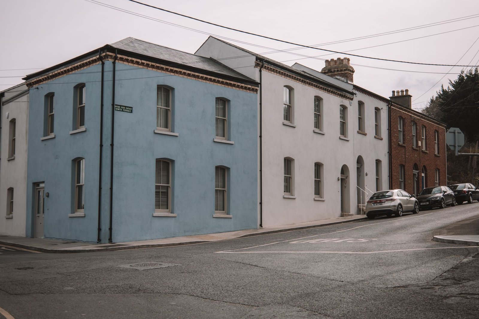 Street view in Dublin featuring vibrant blue, white, and brick houses capturing urban charm.