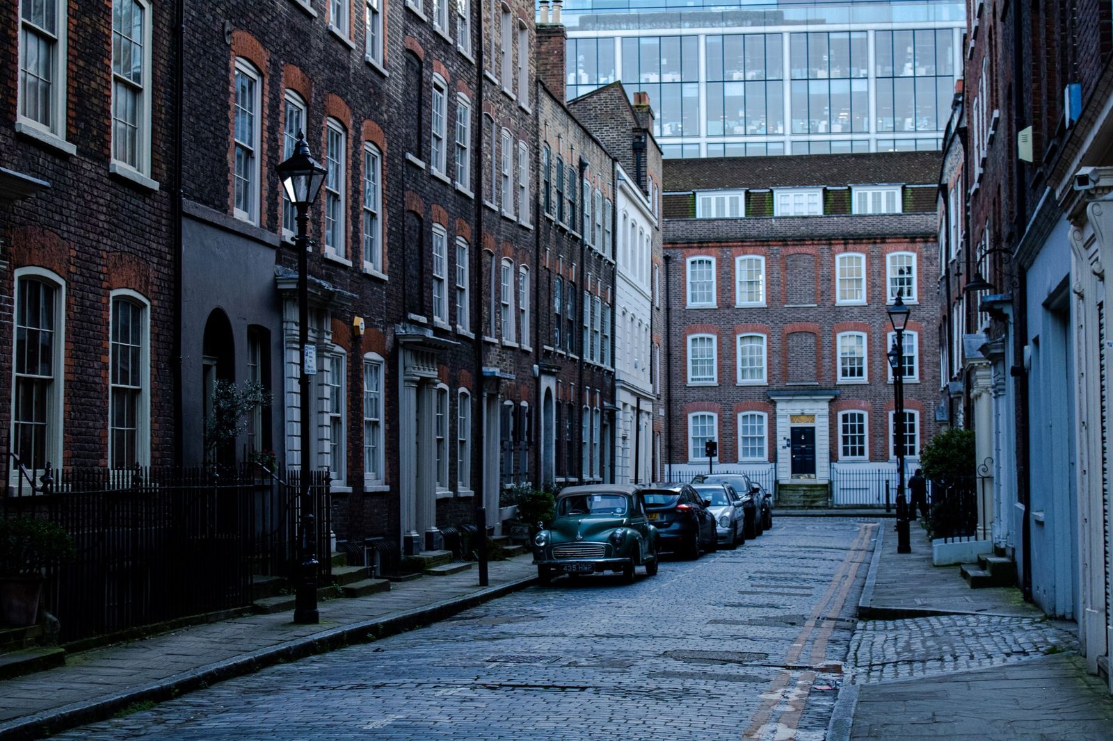 Quaint London street scene featuring historic brick buildings and parked cars, capturing urban charm and architectural elegan