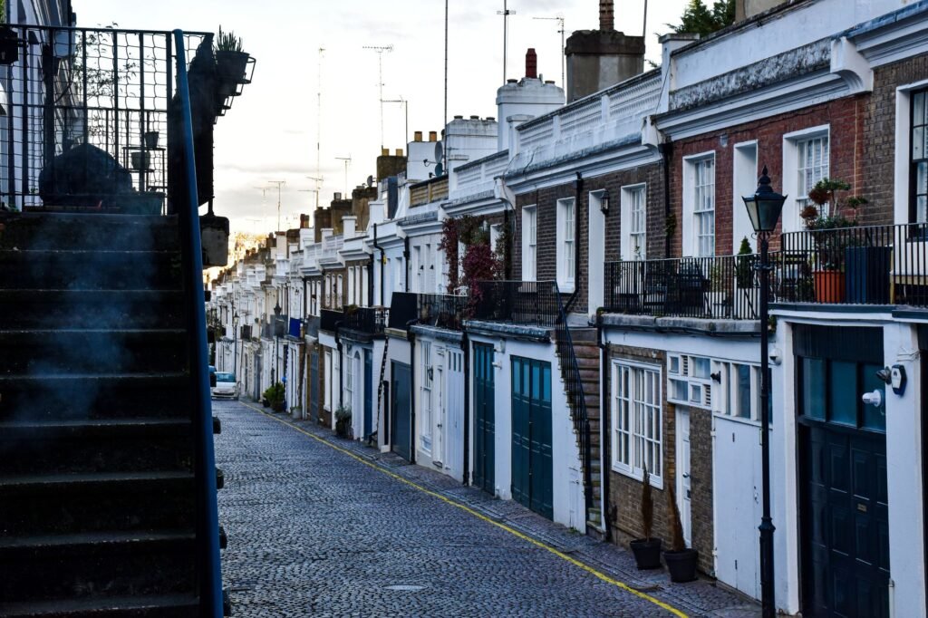 Cobbled street lined with classic townhouses in a quiet London residential district.