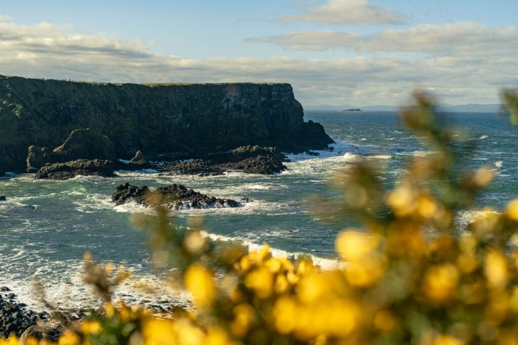 Dramatic view of rugged cliffs and ocean waves in Bushmills, Northern Ireland.