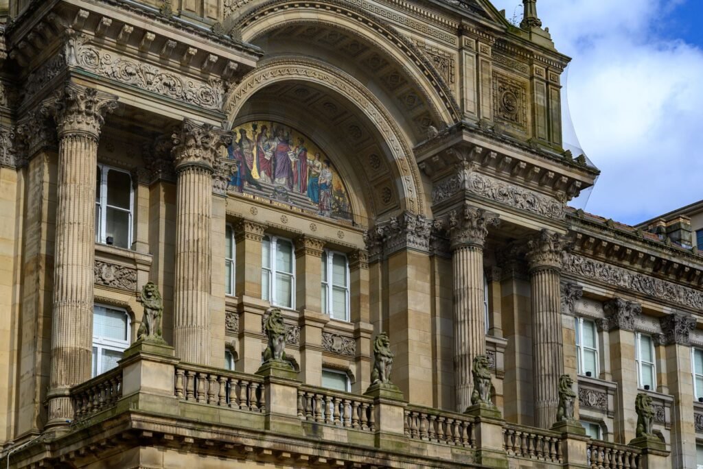 Detailed view of a historic architectural facade in England showcasing ornate columns and sculptures.