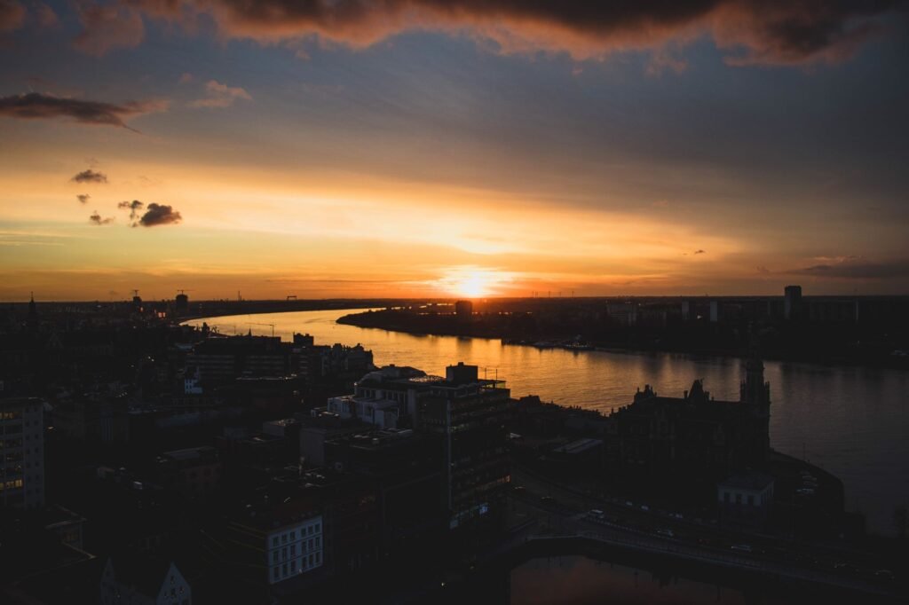 Marvelous sunset view of Antwerp skyline with river and dramatic clouds.