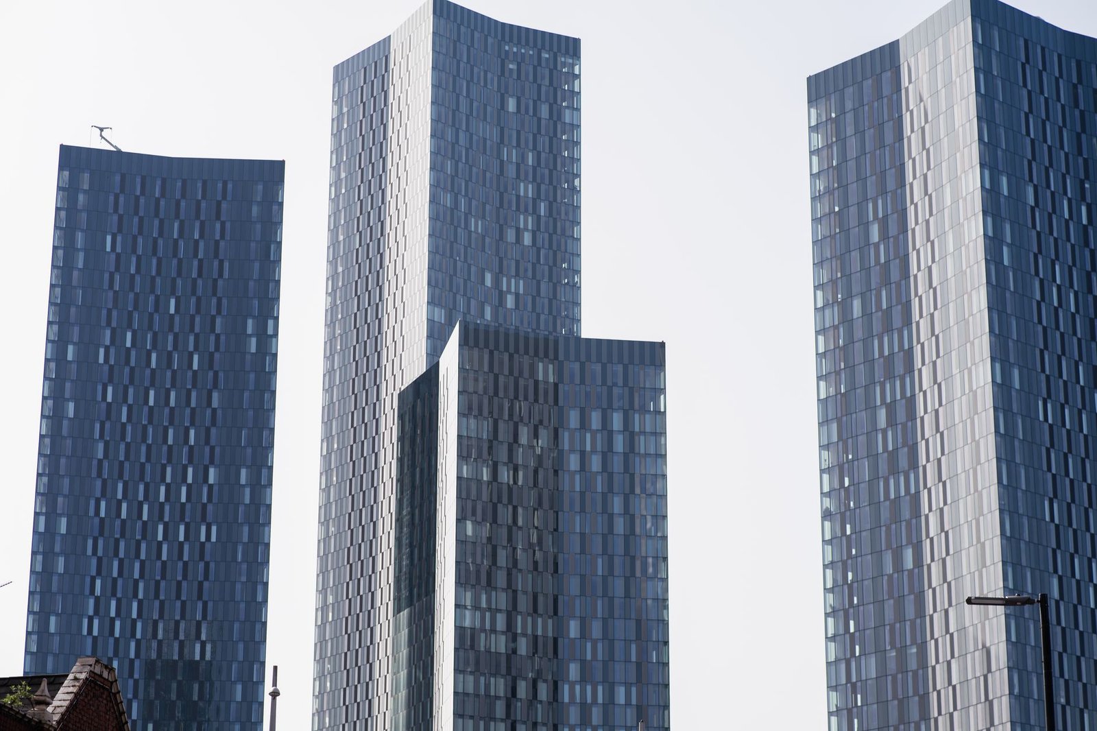 Contemporary skyscrapers in Manchester, showcasing sleek architectural design against a clear sky.