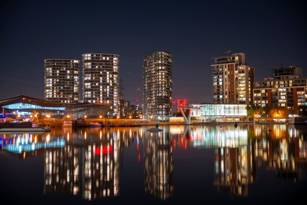 Captivating nighttime view of London's illuminated skyline reflecting on tranquil waters.