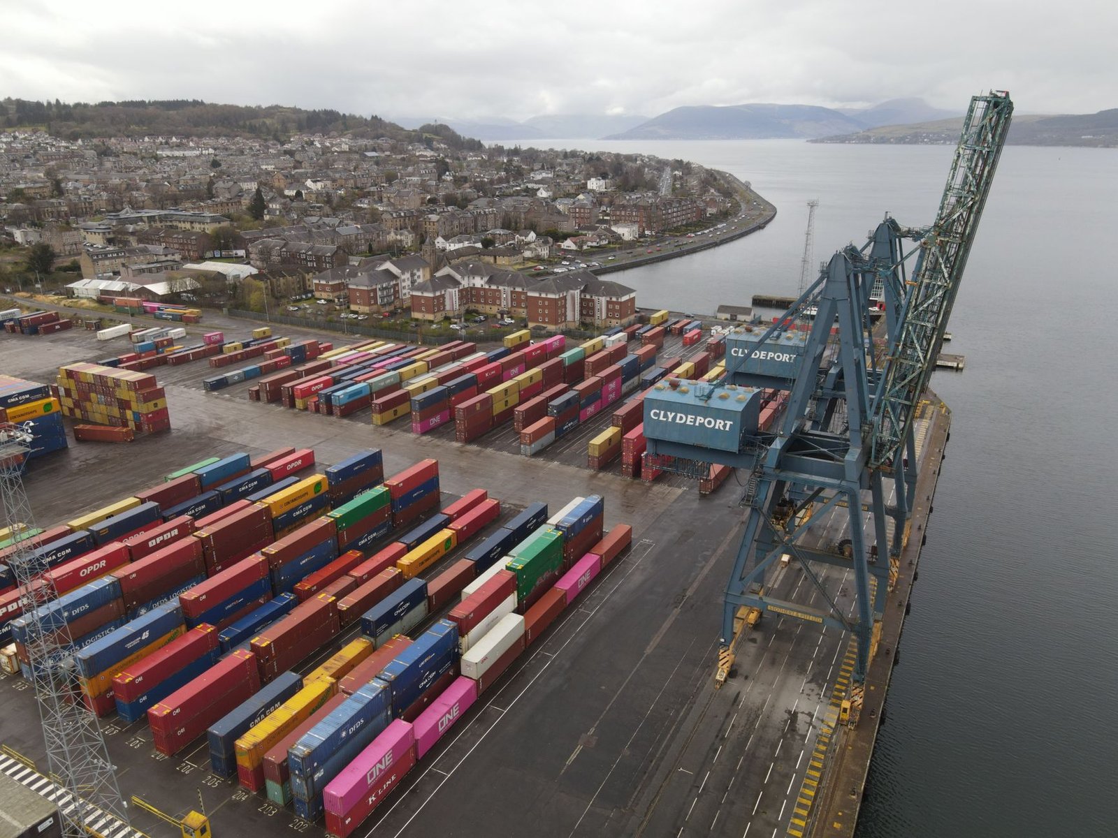 Aerial view of colorful shipping containers at Clydeport, Scotland's busy dockside on a cloudy day.