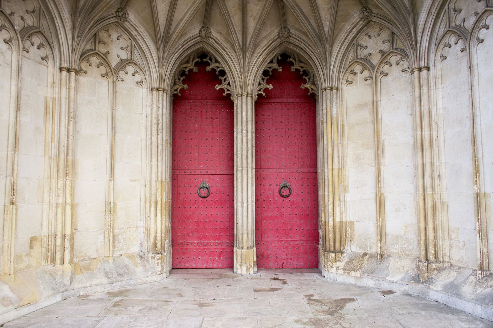Explore the gothic architecture of Winchester Cathedral's red doors and detailed arches in England.