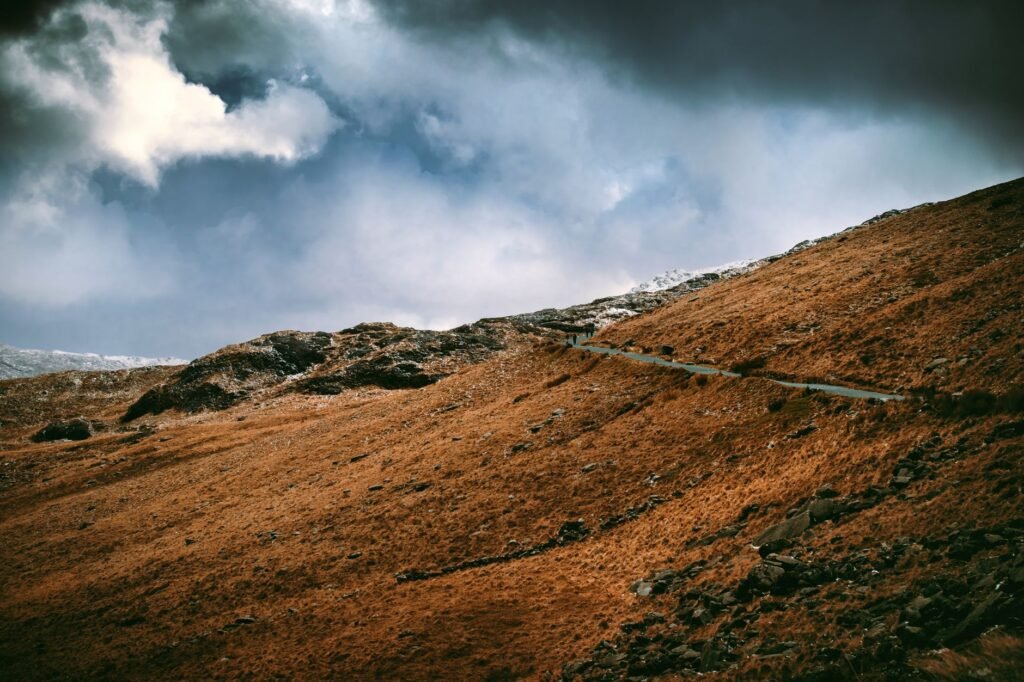 Scenic view of a dramatic hillside under cloudy skies in Gwynedd, Wales.