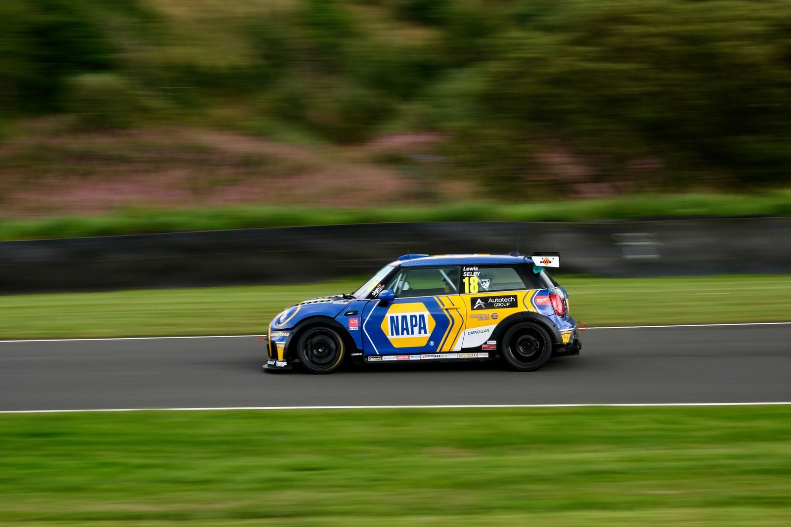 High-speed Mini Cooper racing action at Dunfermline, Scotland, capturing adrenaline and motion blur.