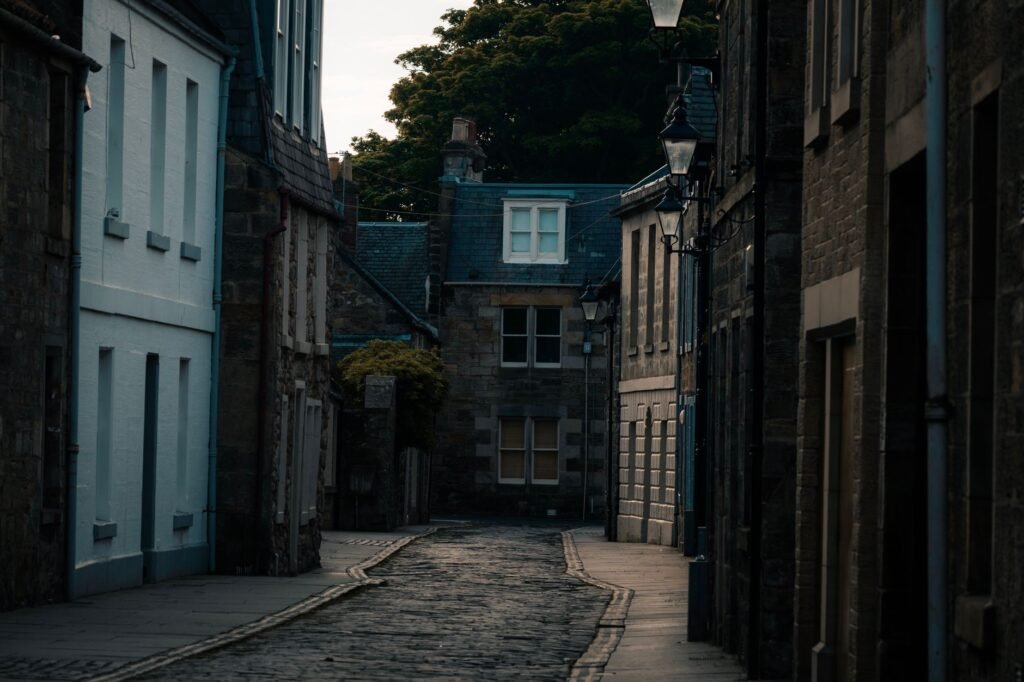 A moody cobbled street between stone buildings, evoking solitude and timelessness.