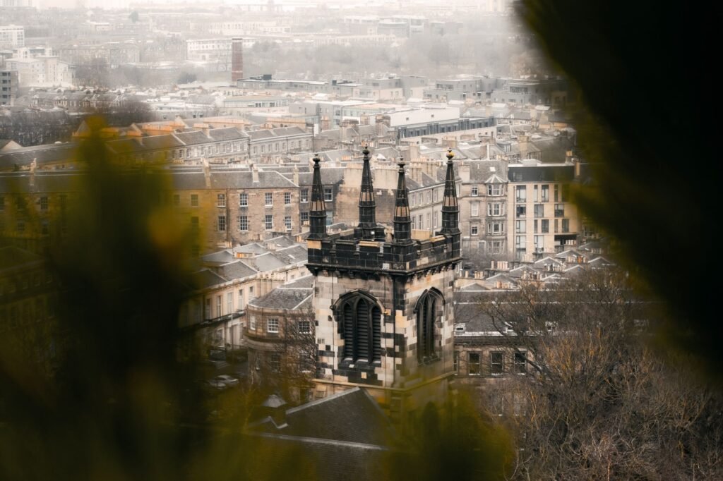 Aerial view of Edinburgh's historic architecture on a moody day, showcasing iconic towers.