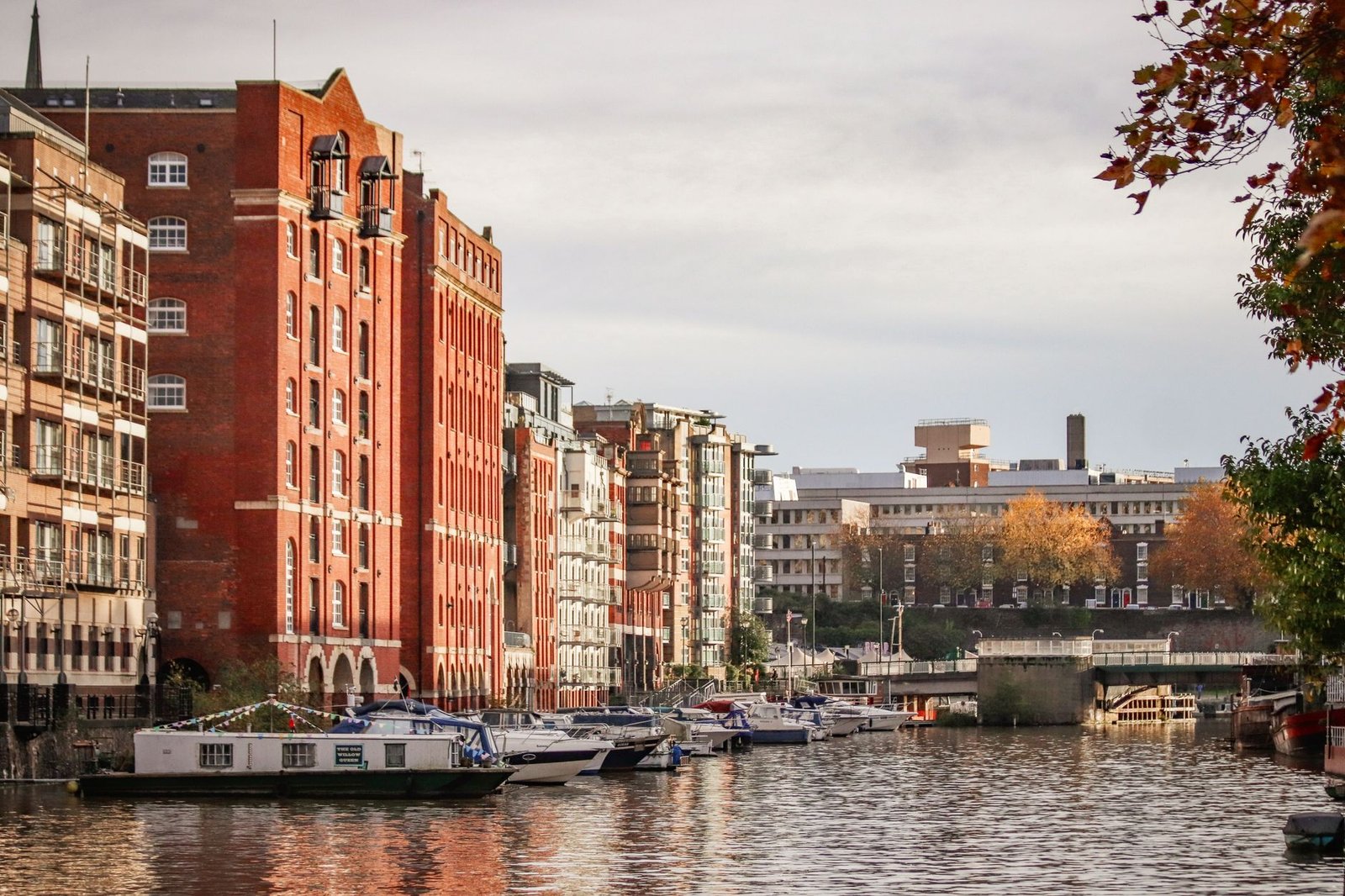 Explore the vibrant waterfront cityscape of Bristol's Floating Harbour with historic buildings and moored boats.