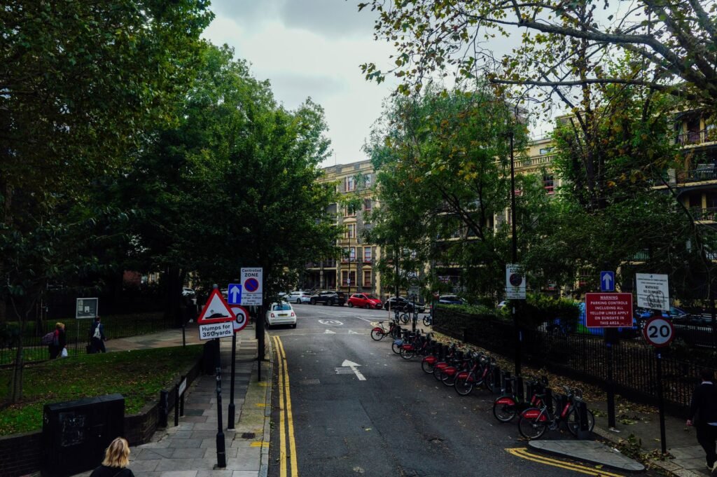 Scenic urban street view with parked bicycles and lush trees on a calm autumn day.