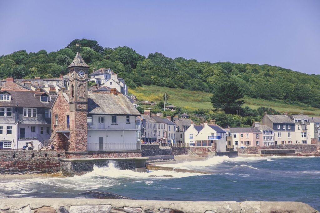 Charming coastal village scene with clock tower and colorful houses in Kingsand, UK.