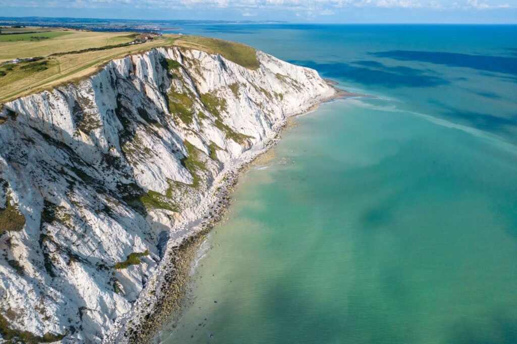 Breathtaking aerial view of Eastbourne's white cliffs on a sunny day along the English Channel.