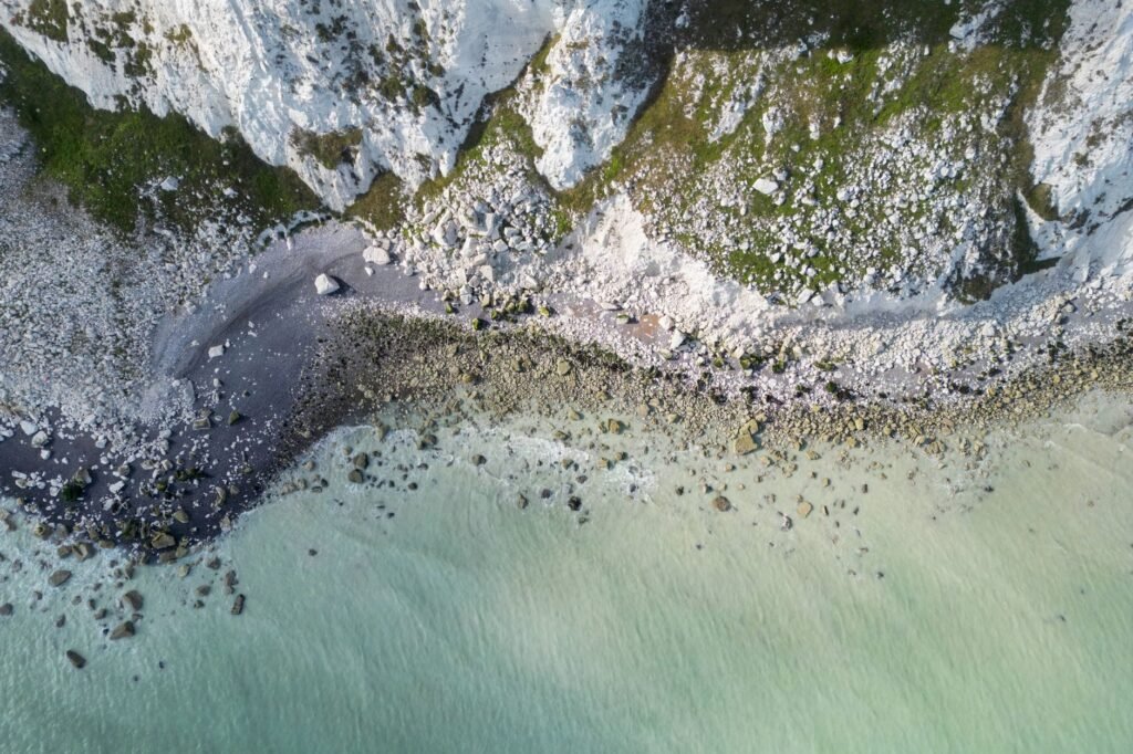 A stunning aerial view of Eastbourne's white cliffs and rocky shore in England.