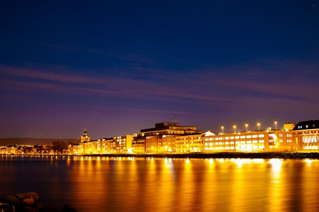 Breathtaking night view of Jönköping's illuminated waterfront reflecting on Lake Vättern.